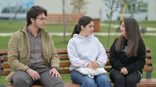 Students talking while sitting on the bench