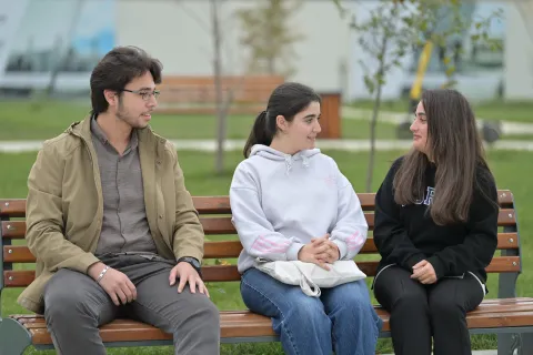Students talking while sitting on the bench